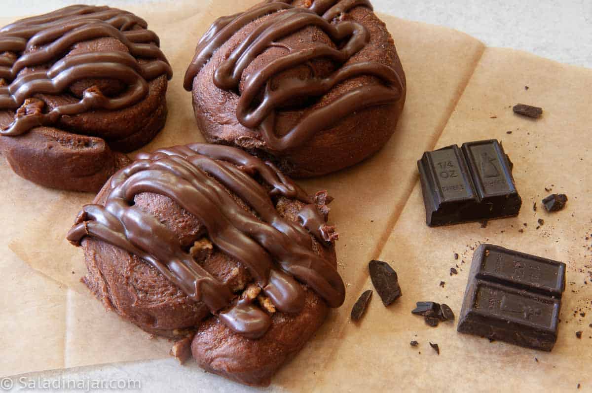 Chocolate Snails or buns sitting next to chocolate pieces