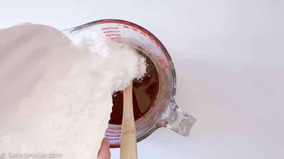 adding powdered sugar to melted chocolate