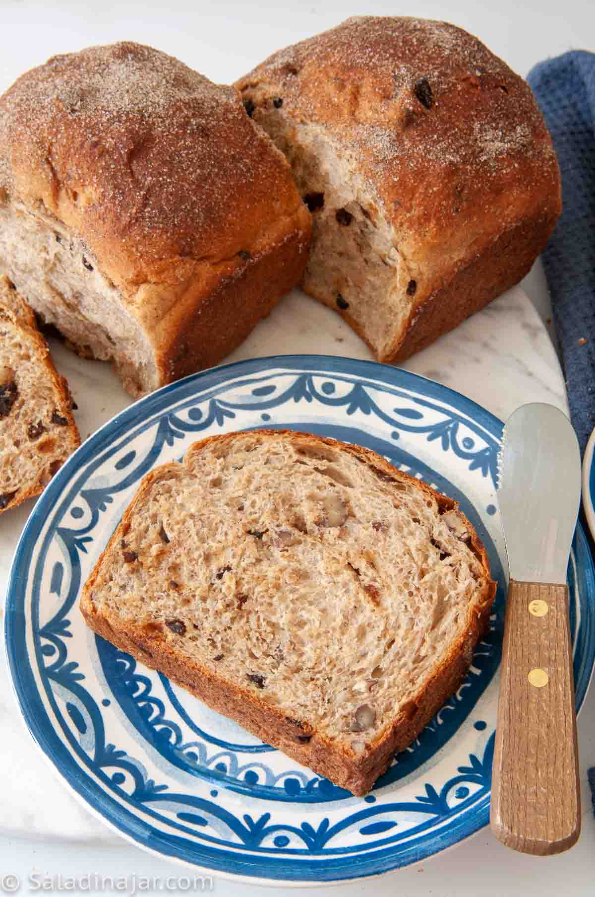 a slice of Healthy Banana Whole Wheat Bread next to some mini-loaves.