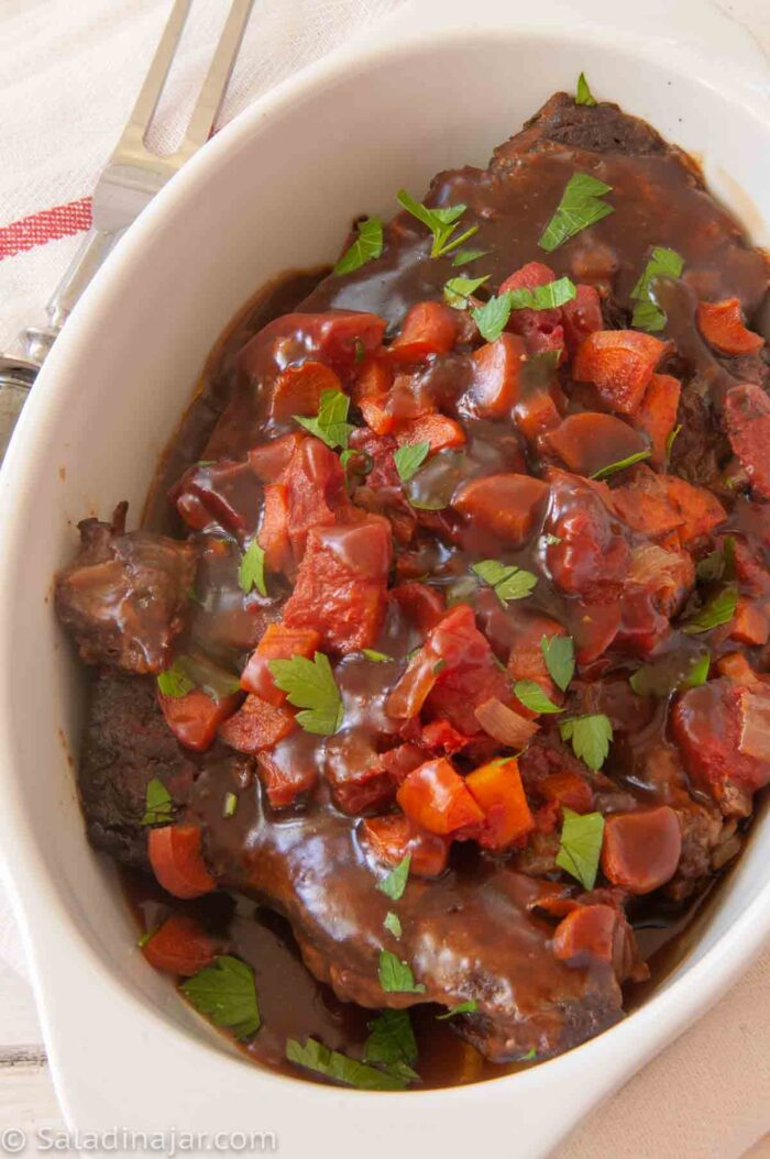 Slow Cooker Deviled Swiss Steak--in white serving dish; ready-to-serve