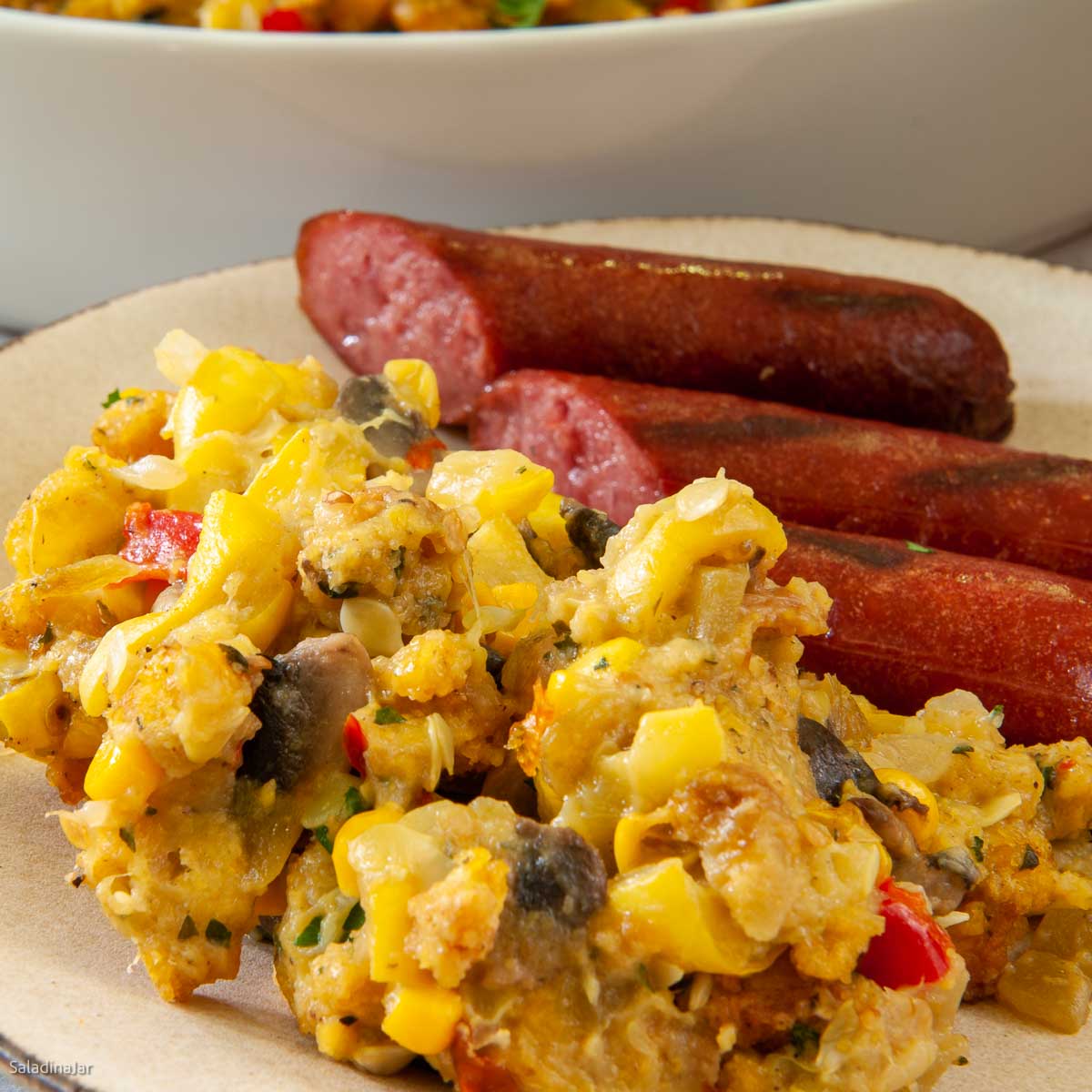 Yellow squash casserole with Leftover Cornbread on a plate with smoked sausage