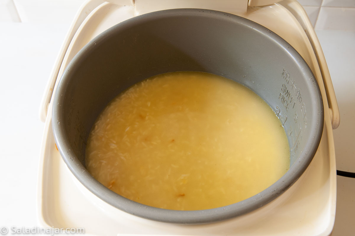 placing the pan of rice into a rice cooker