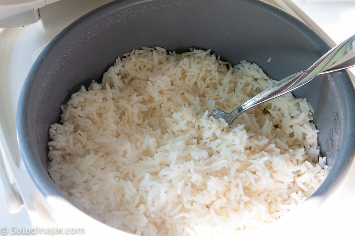 fluffing the rice with a fork.