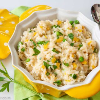 Cheesy Rice in serving bowl with spoon