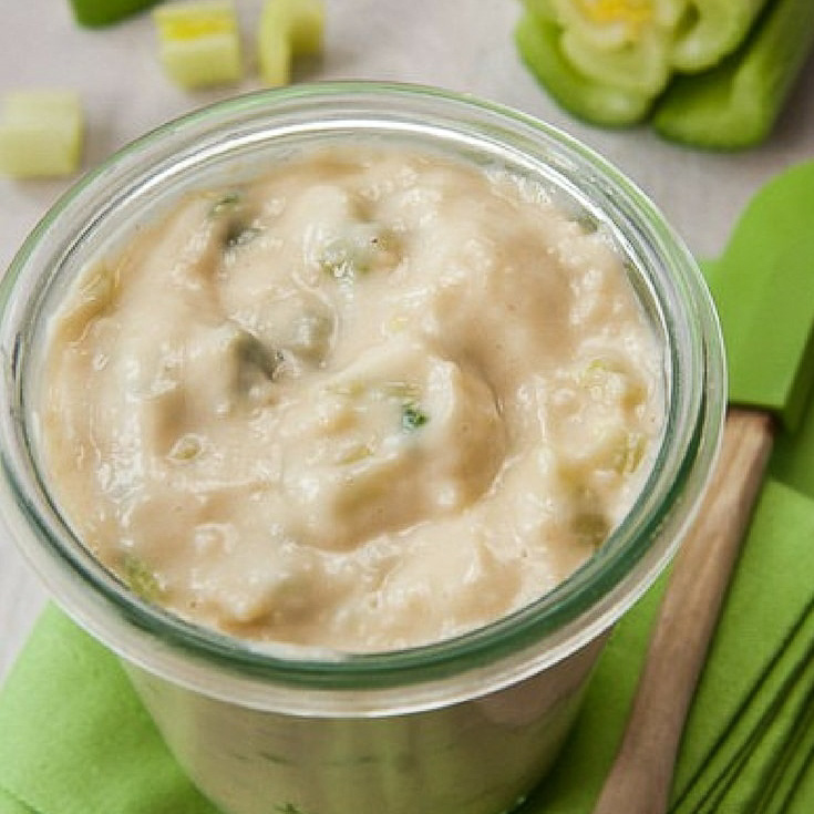 condensed cream of celery soup made from scratch in a glass jar with a spatula on the side.