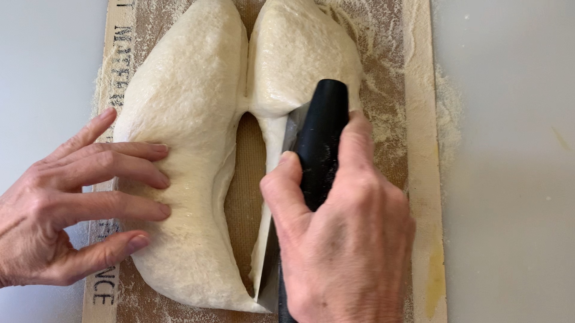 dividing the dough in two pieces with a bench scraper