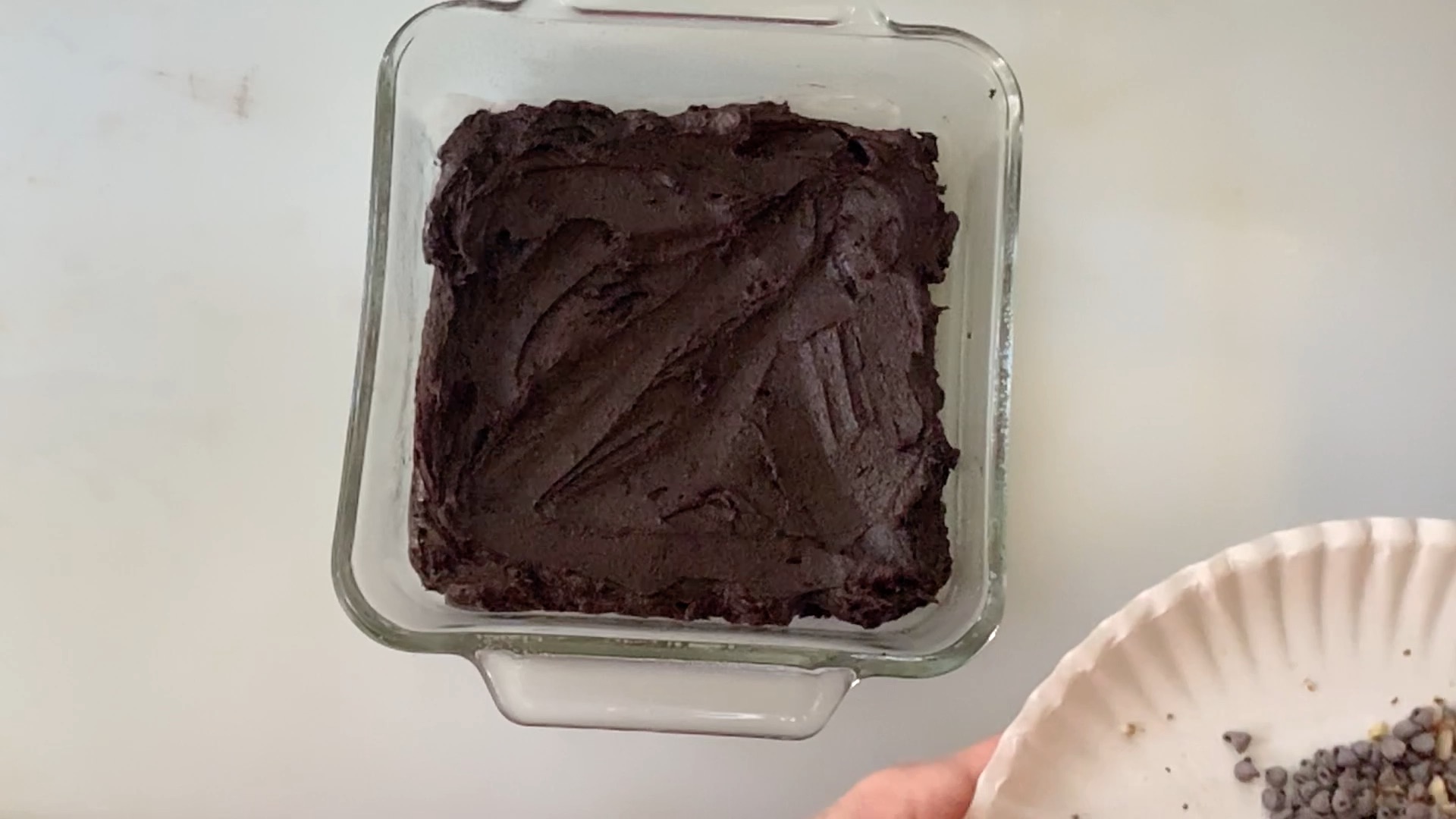 Spreading brownie batter in a glass dish.