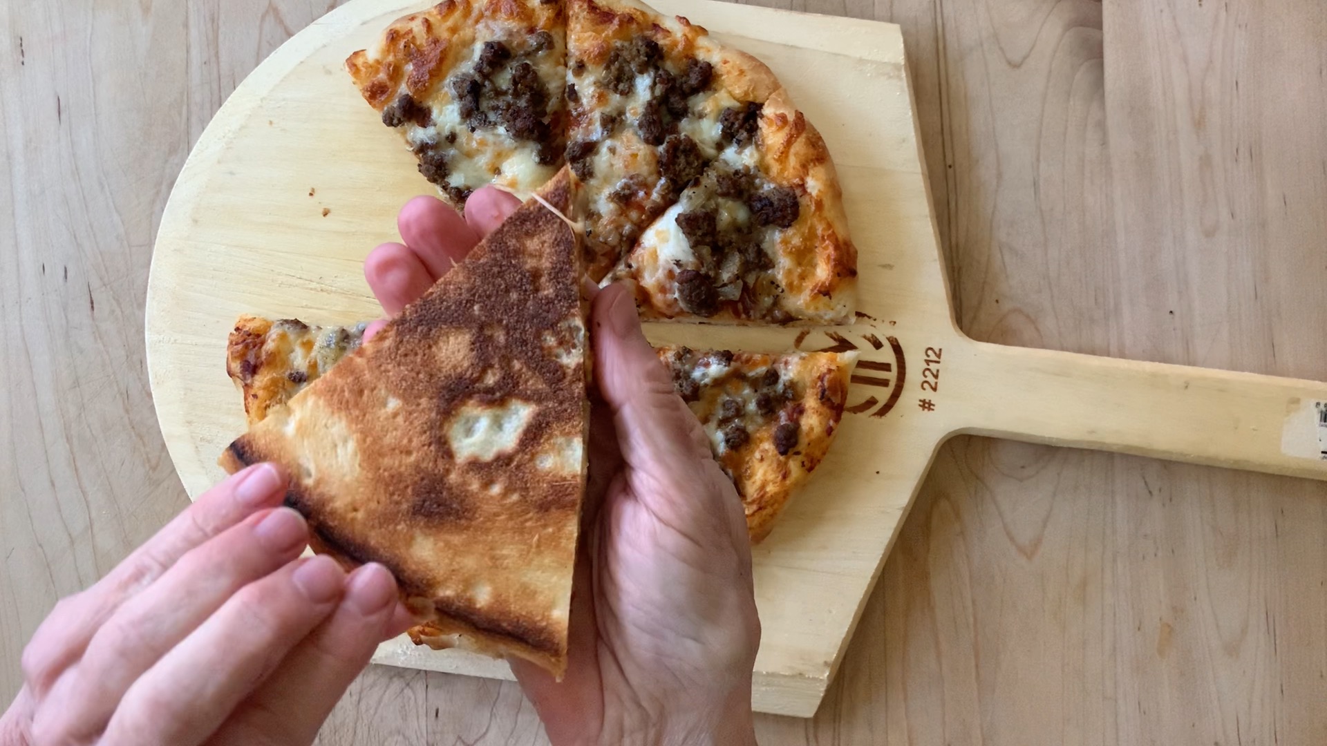 examining the bottom of the crispy, brown crust