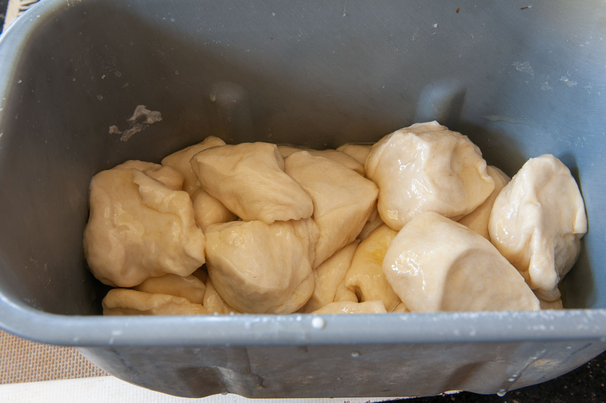 raw dough pieces inside bread machine pan