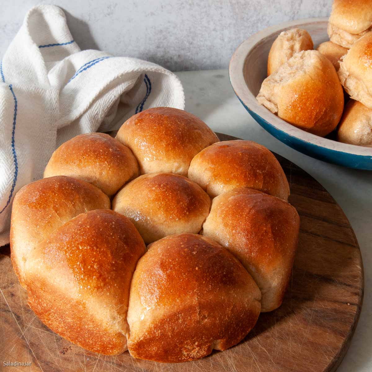 baked whole wheat rolls on a cutting board.