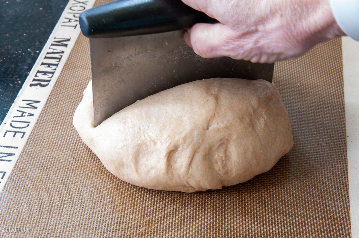 using a bench scraper to portion dough