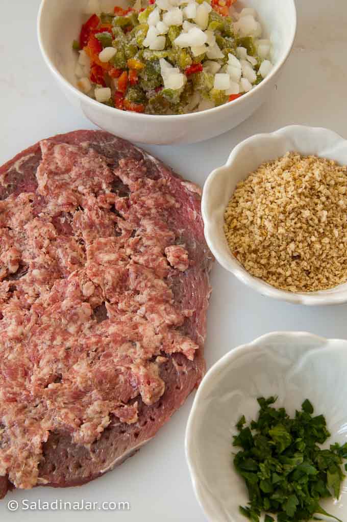 stuffing the steak with sausage and some seasoning vegetables.