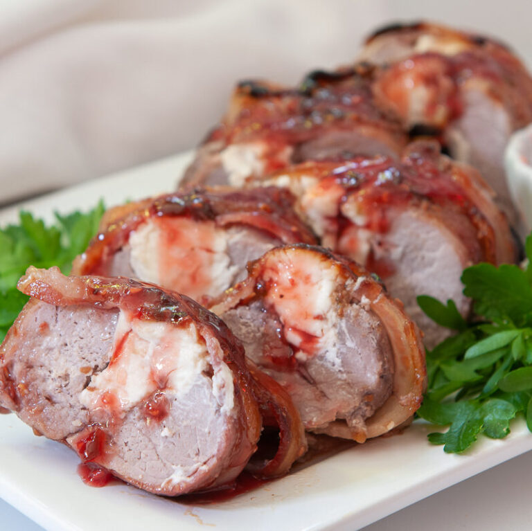 Stuffed Pork Tenderloin Wrapped in Bacon with Raspberry Chipotle Sauce