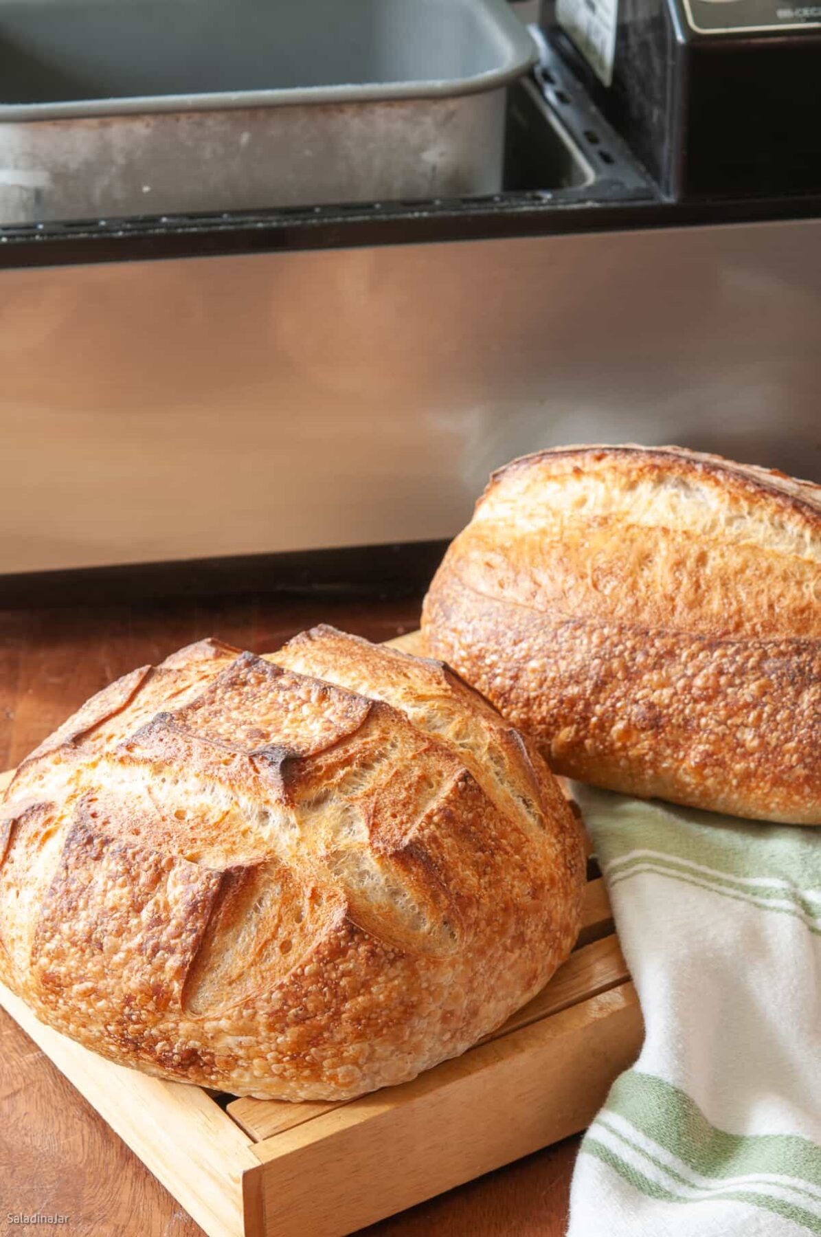 sourdough loaves in front of machine they were made with