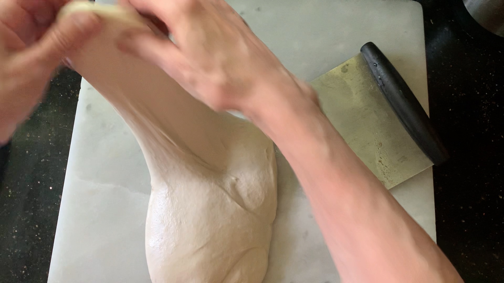 Stretching and folding the dough during pre-shape.