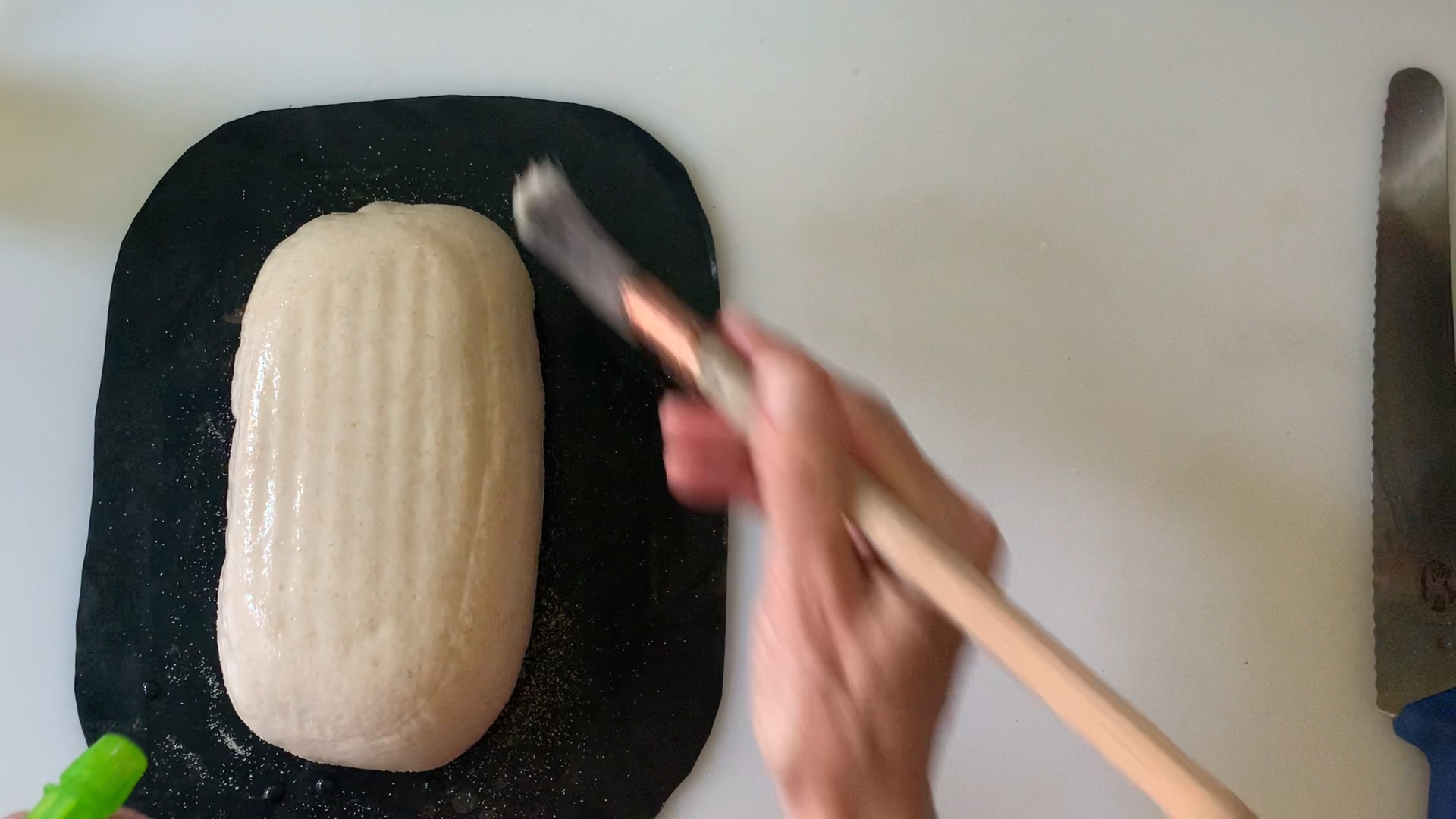 brushing and spraying the loaf with water--hoping for blisters