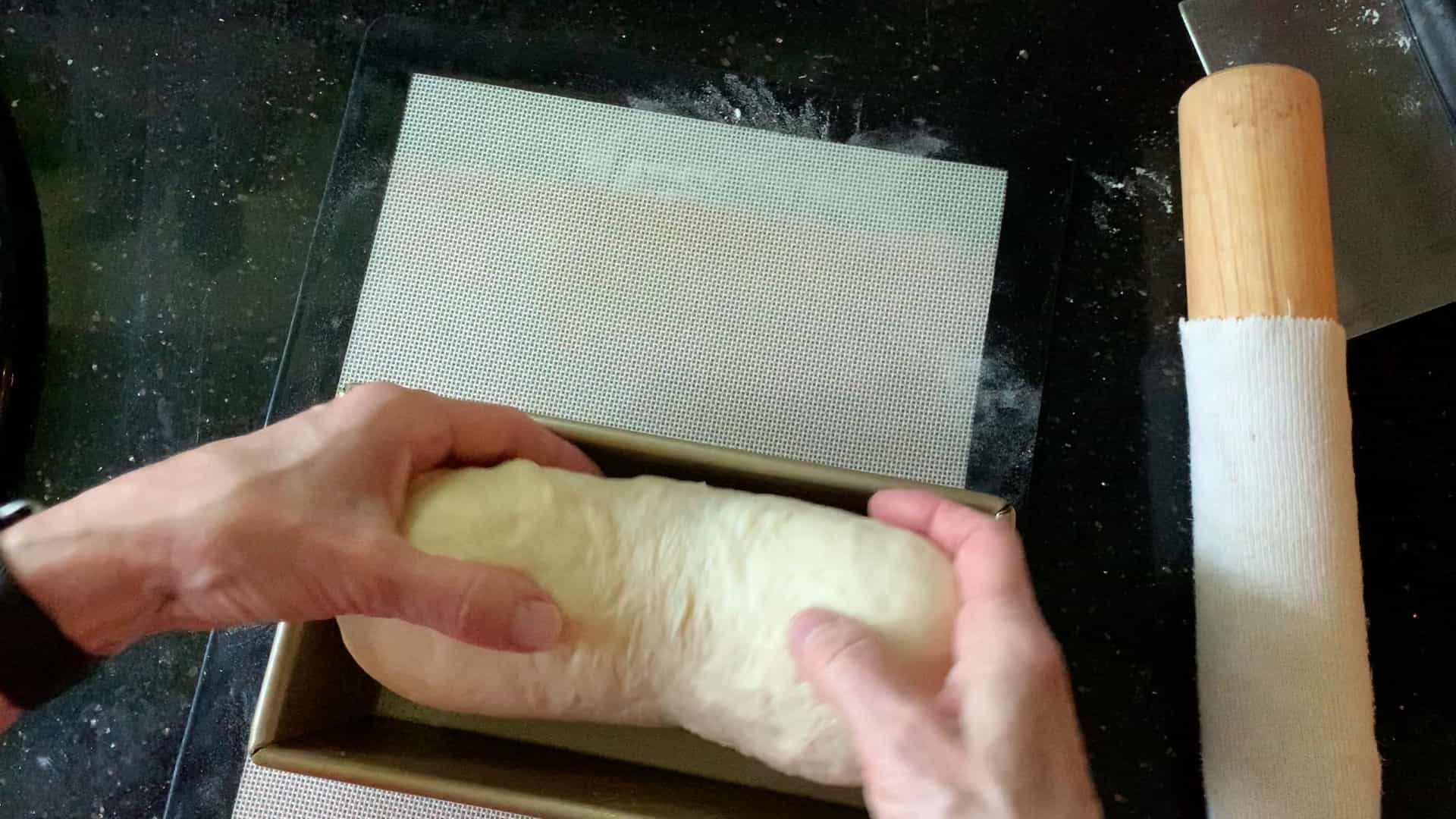 placing dough into the loaf pan.