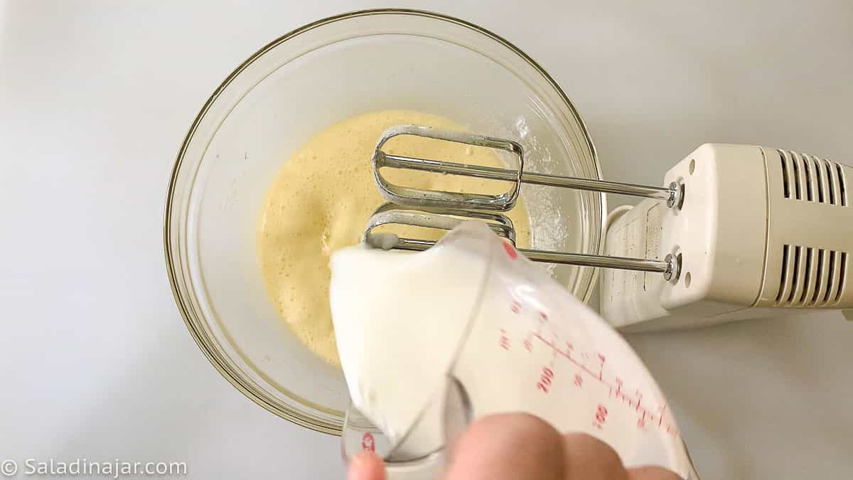 adding milk to eggs and sugar