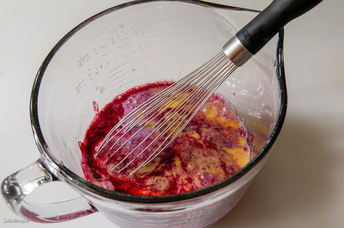 mixing eggs into blackberries