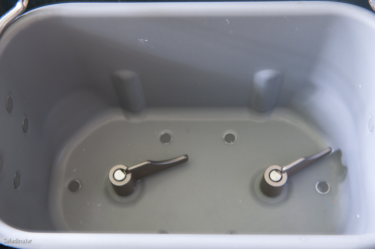 inside of a bread machine pan showing the paddles installed correctly.