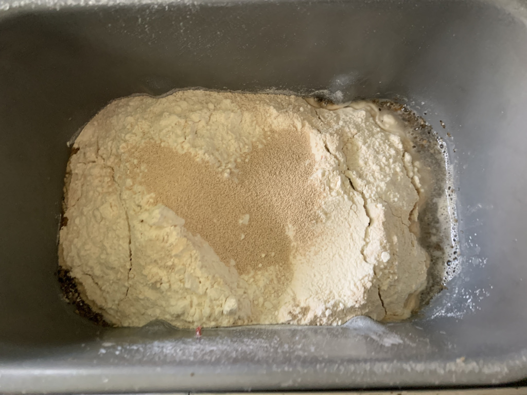adding ingredients to bread machine pan.