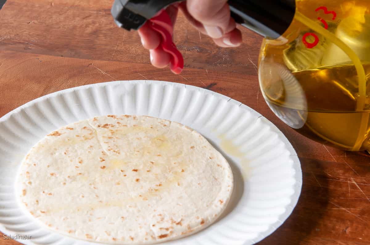 spraying tortilla bowls with oil