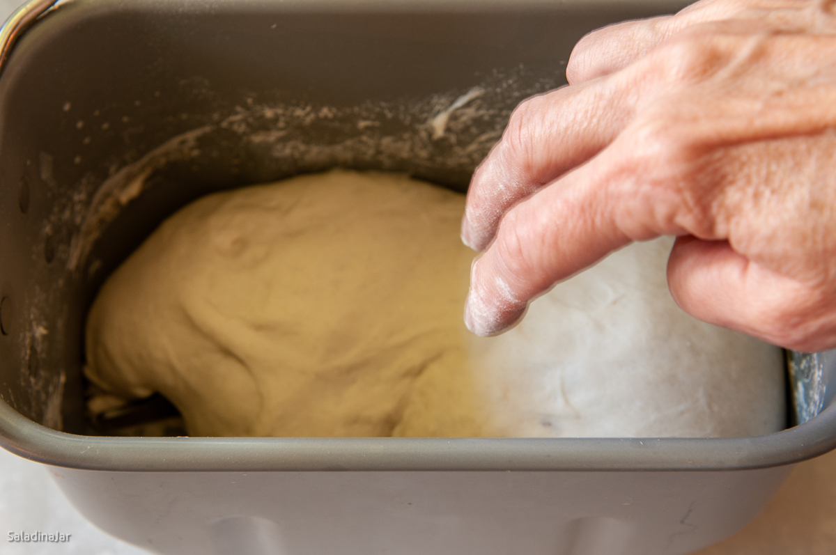 testing dough with two floury fingers