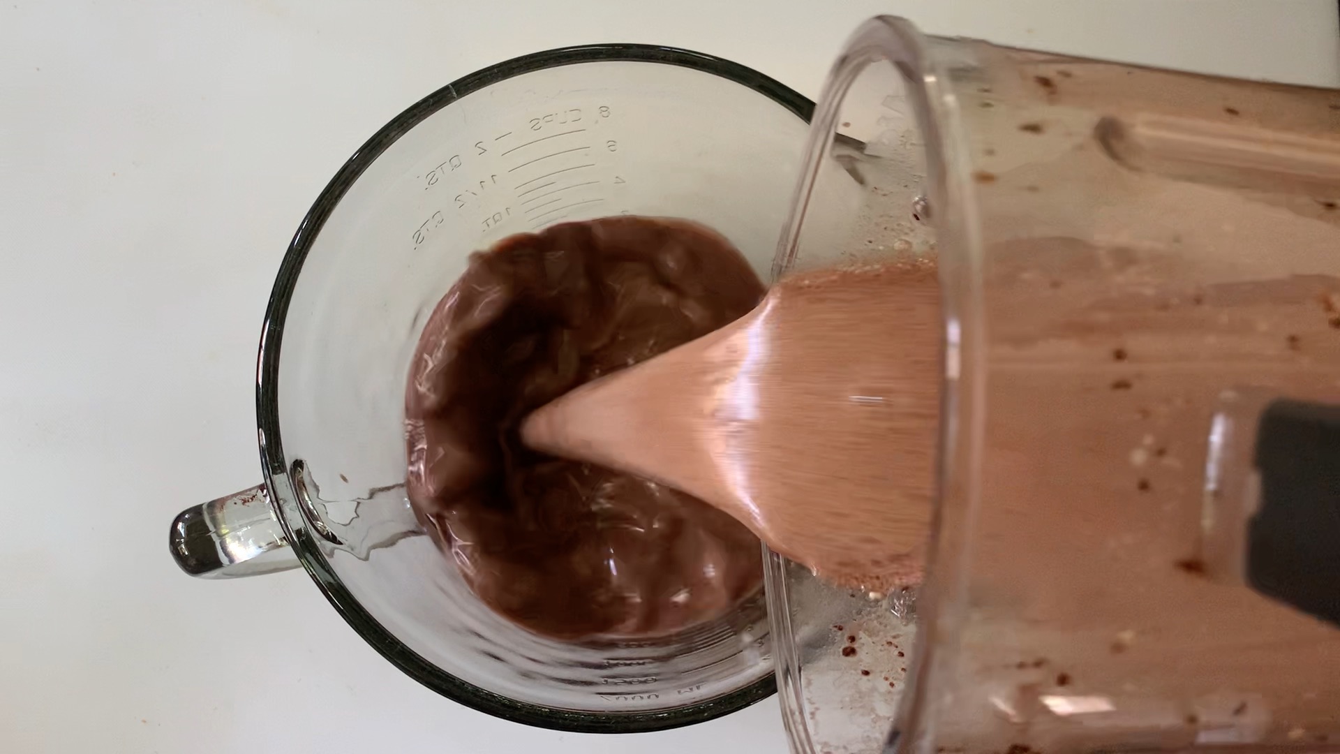 Pouring chocolate filling mixture into a microwave-safe Pyrex mixing bowl.