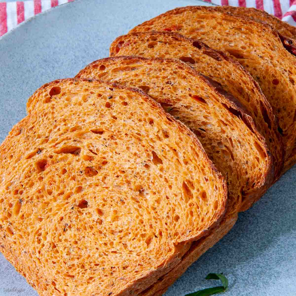 sliced tomato basil bread from a bread machine on a plate