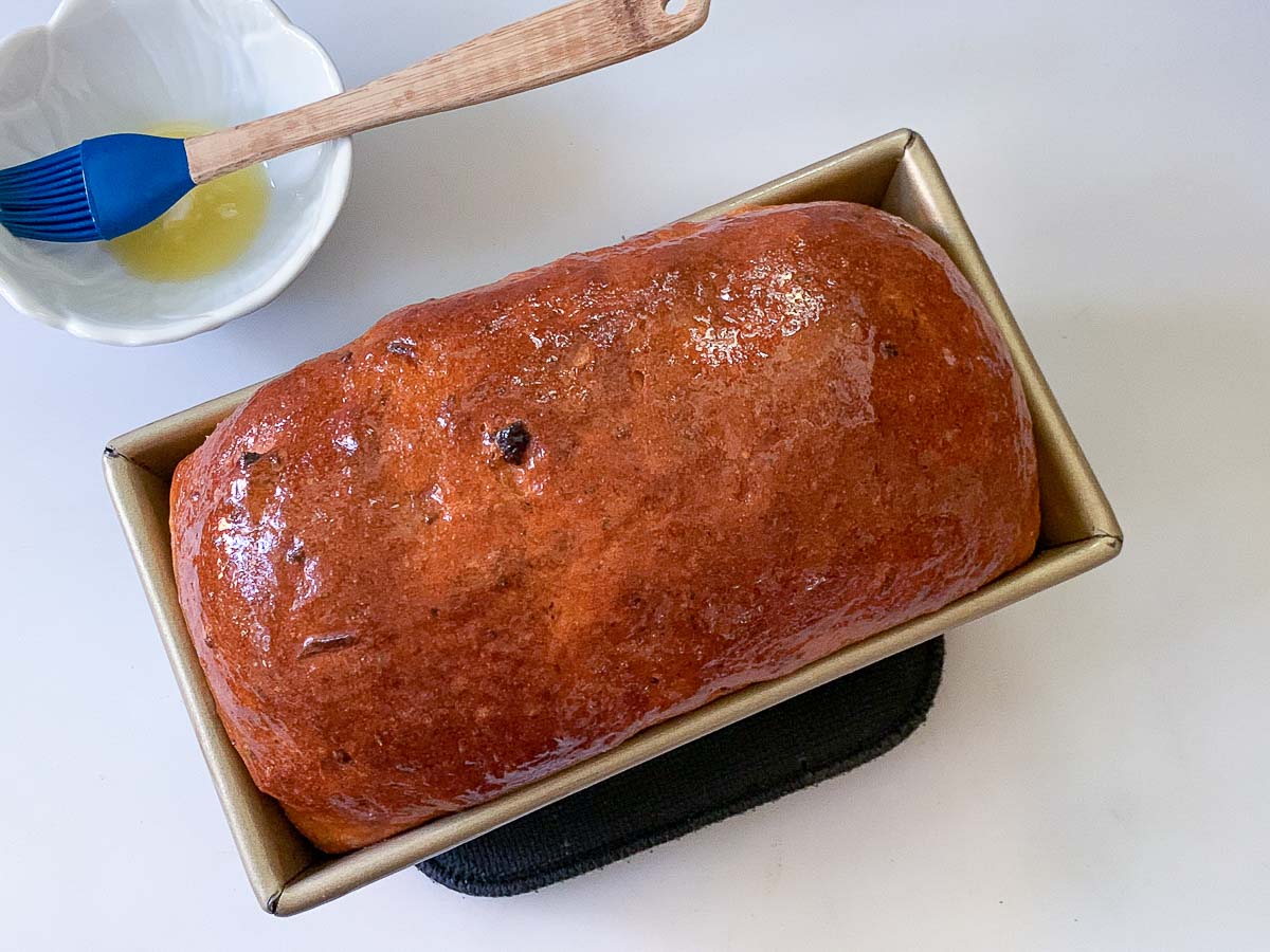baked tomato basil loaf coated with butter.