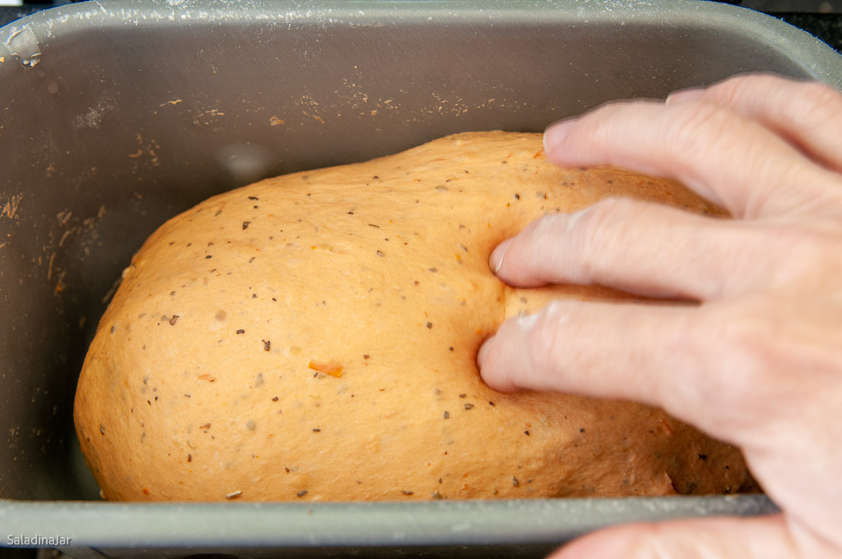 testing dough with two fingers