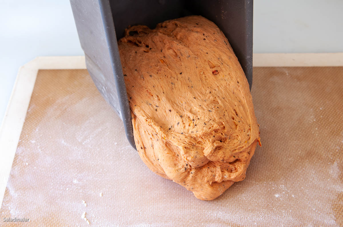 removing dough from bread machine pan.