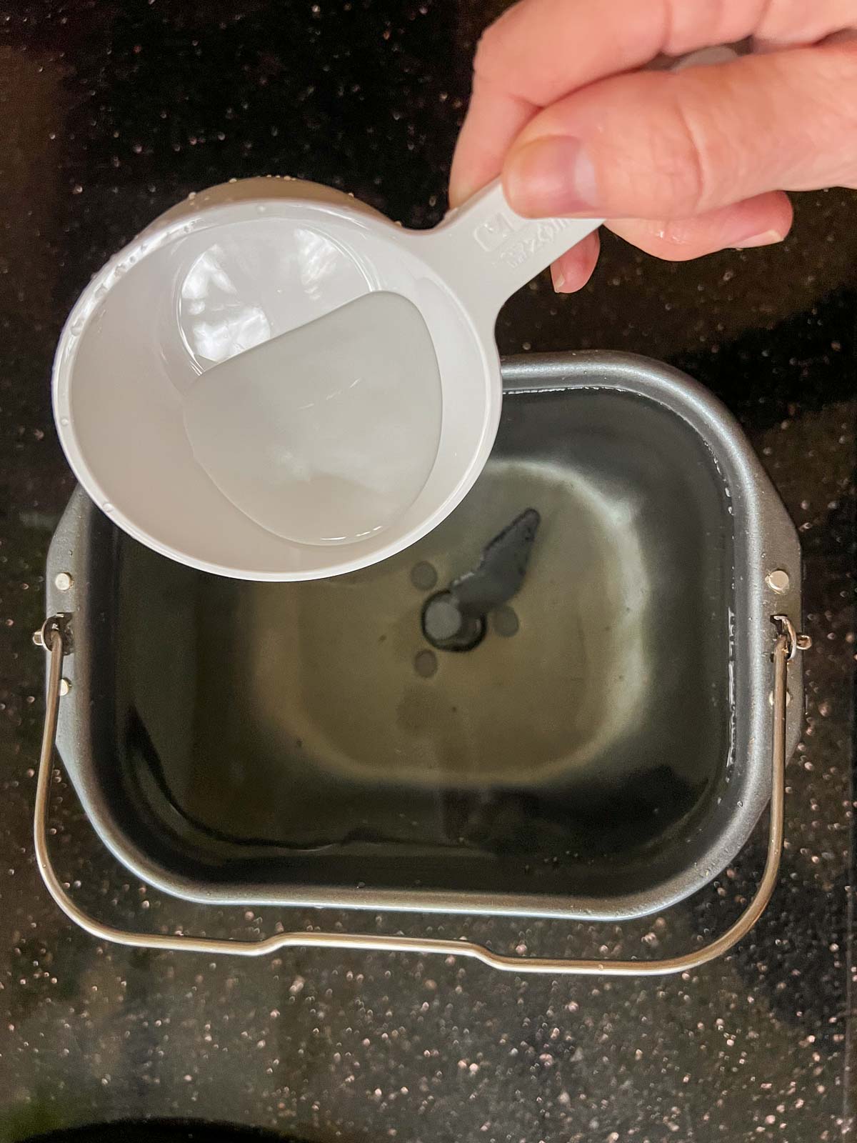 measuring size of bread maker pan with water.