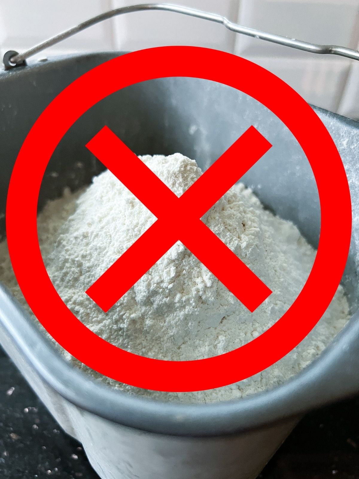 A bread machine overloaded with a double recipe and excess flour, marked clearly with a red X to indicate a misstep. 