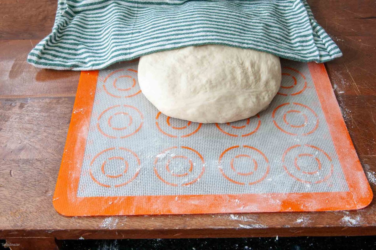 when the dough cycle ends, removing dough from the machine and shapng into a ball so it can rest covered for 10-15 minutes.