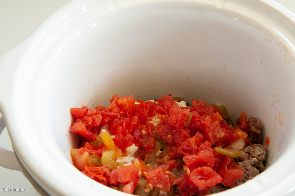 meat and tomatoes added to slow cooker