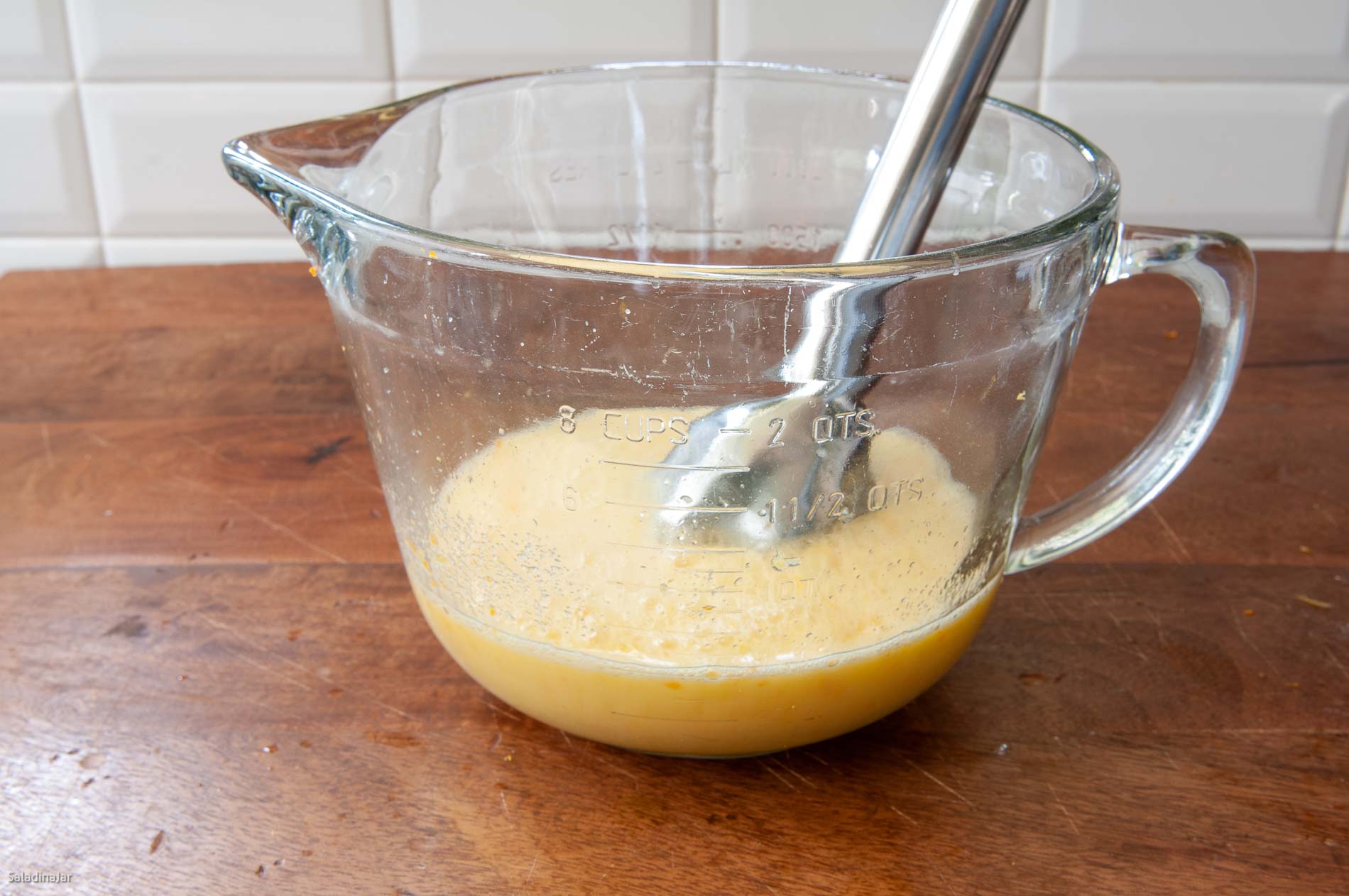 Using an immersion blender to thoroughly mix the eggs, sugar, juice, rind and salt.