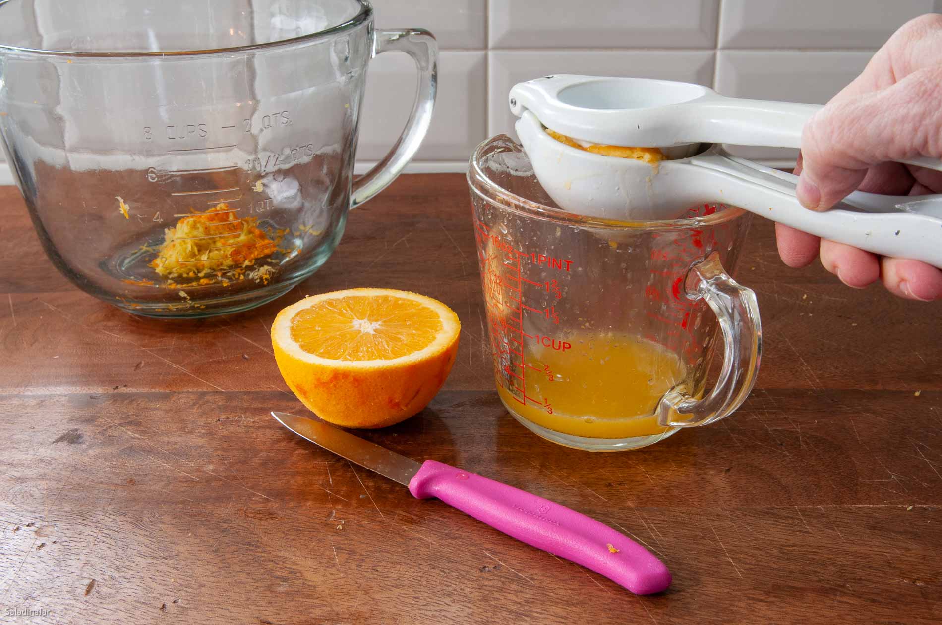 Squeezing juice out of the oranges.