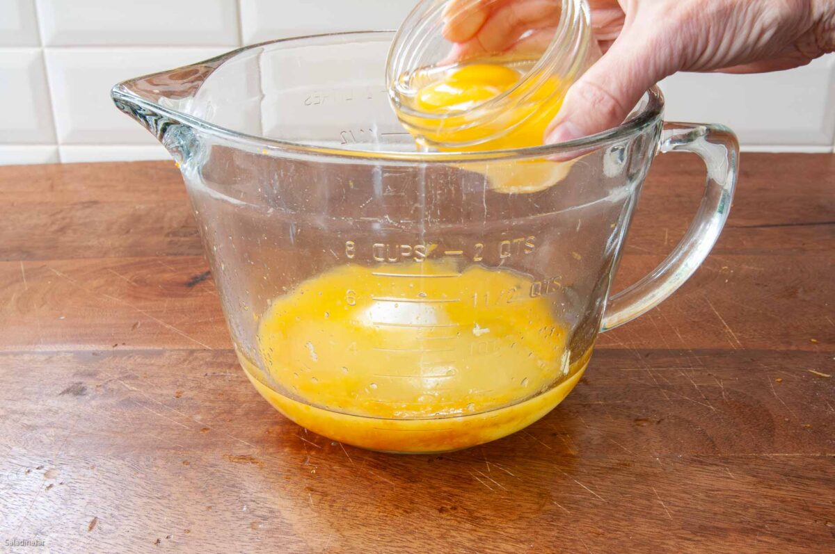 Adding the sugar and eggs to the juice mixture.