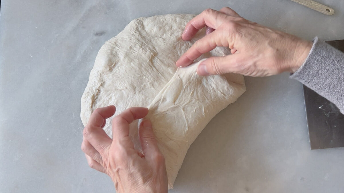 folding the dough to shape a batard.