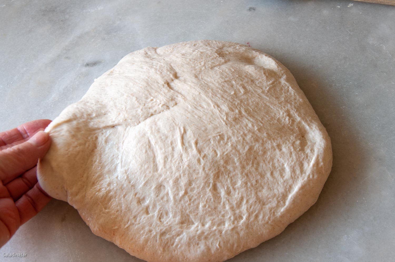 after the bench rest, flipping the dough and reshaping it.