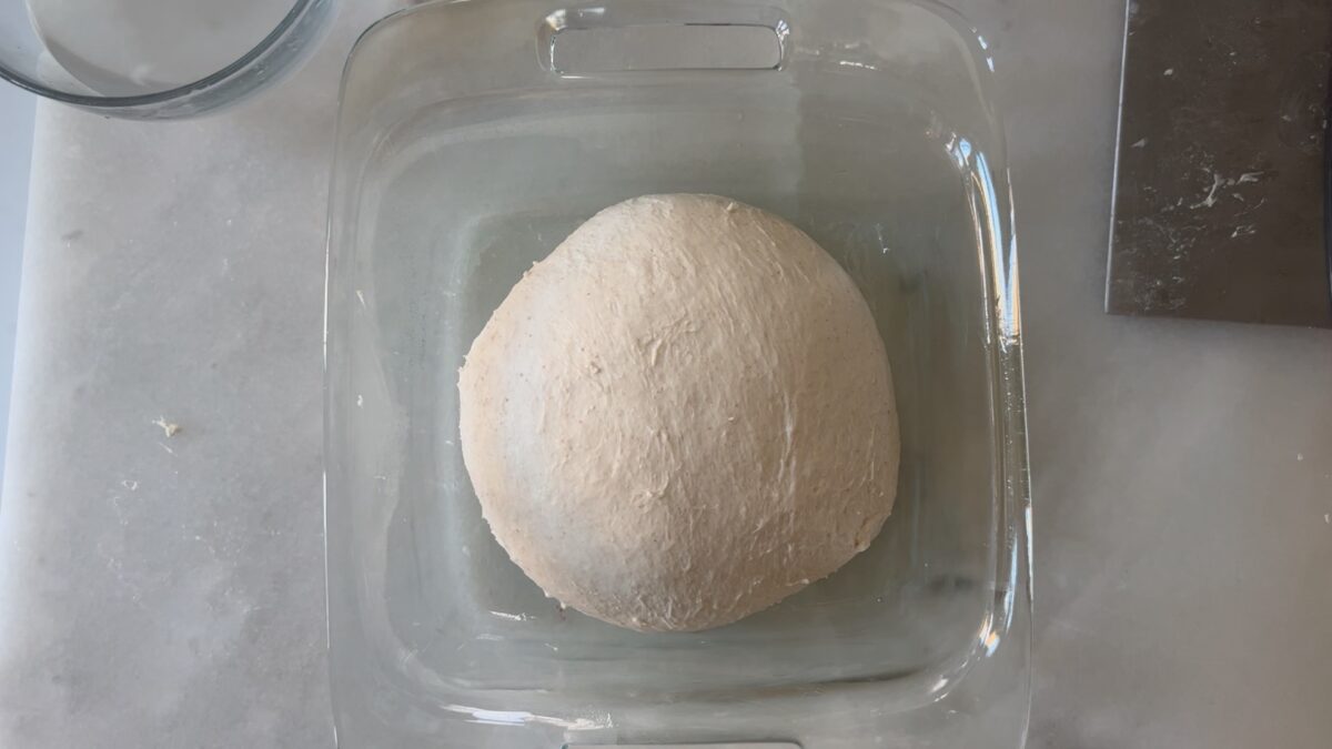 dough in glass dish at the beginning of the bulk rise.