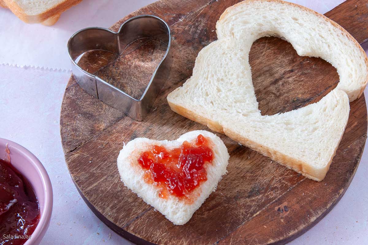 white bread with a cookie cutout spread with jelly