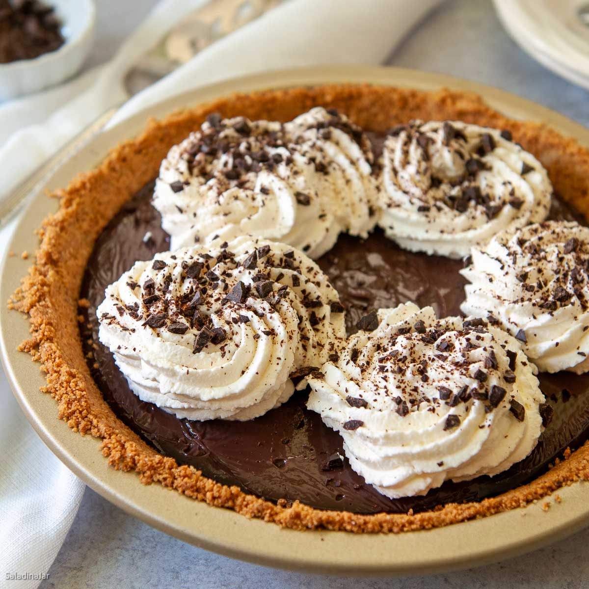 microwave chocolate pie garnished with shipped cream and choolate shavings.