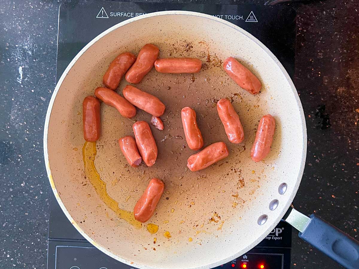 browning link sausage in a skillet.