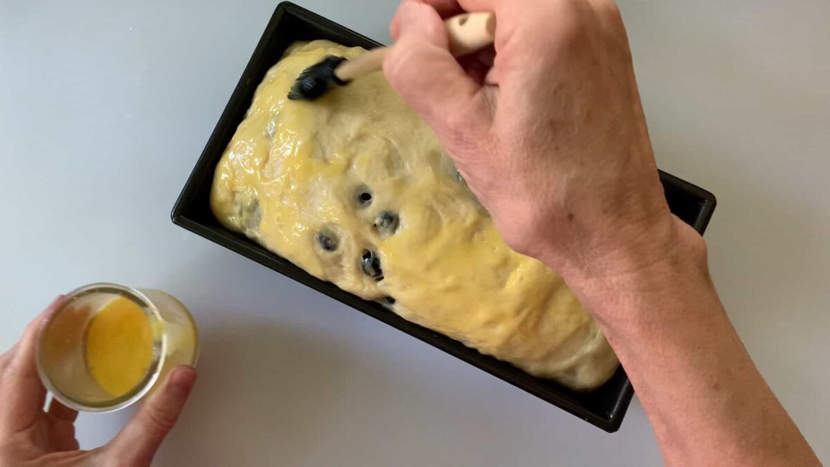Glazing the top of the loaf.