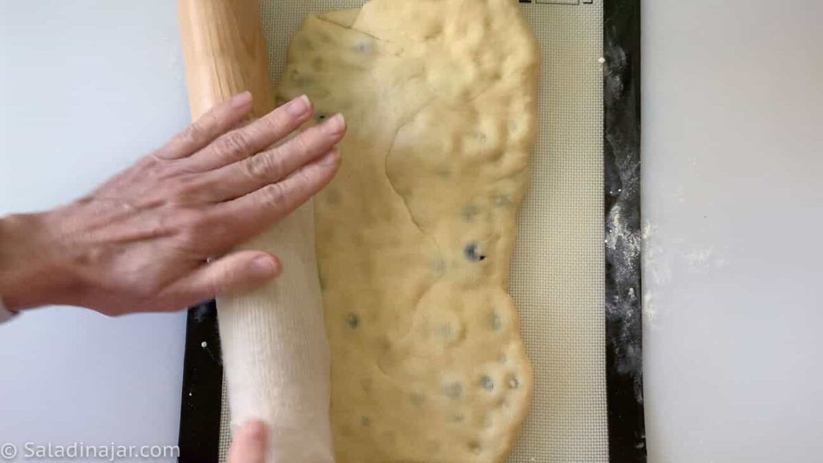 Fold dough over the blueberries like a business letter and lightly roll over it with a rolling pin.