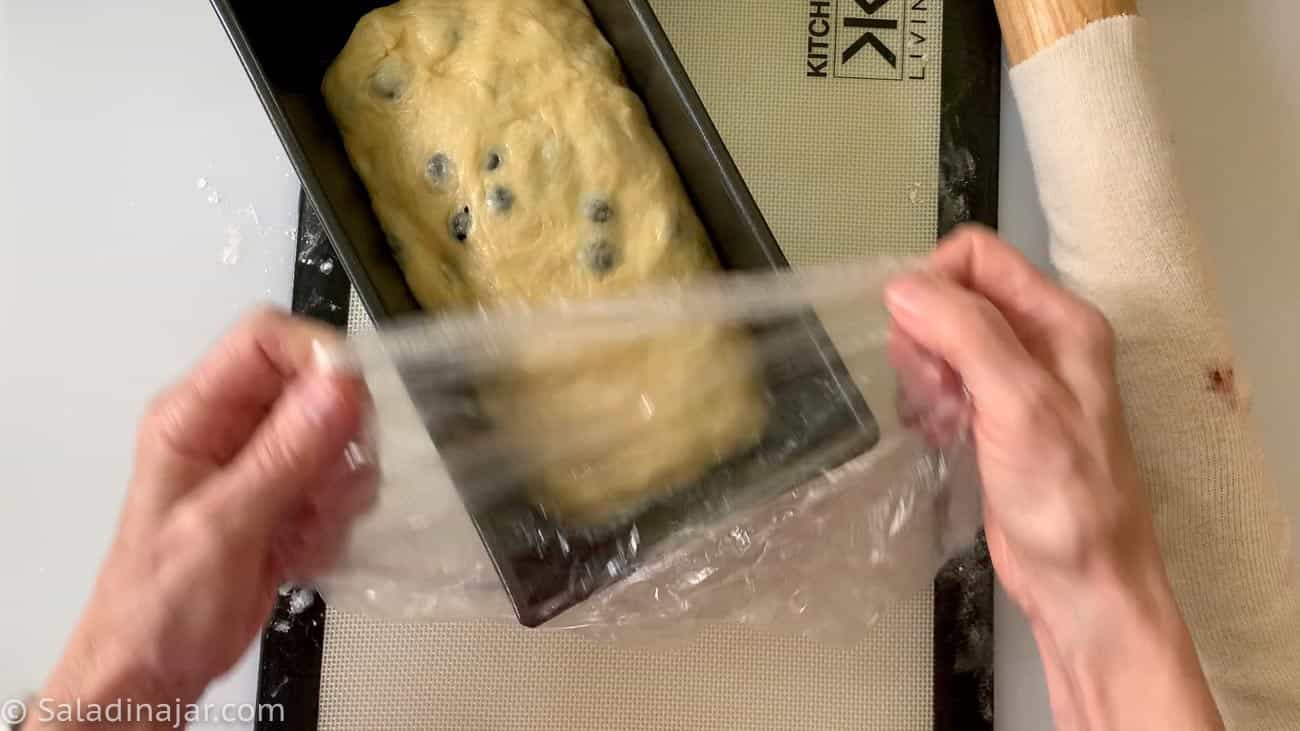 placing dough into the pan and covering it to rise a second time