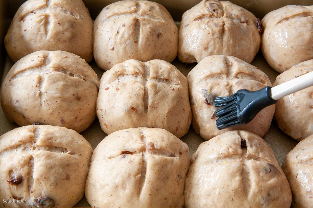 brushing the buns with glaze.