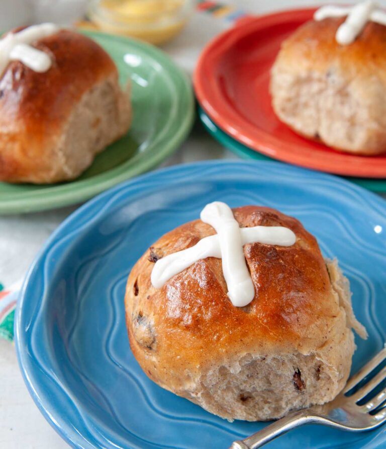hot cross buns on brightly colored plates.